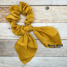 Load image into Gallery viewer, Rory Gail Handmade Satin Knotted Bow Scrunchie in the color, Mustard
